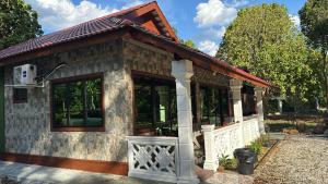 a small house with a large window at D'Kebun Lenggong Perak Chalet in Kampong Ulu Jepai