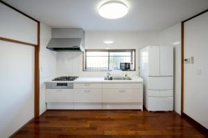 a white kitchen with a sink and a refrigerator at 晴宿-Hareyado 