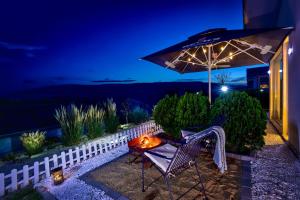 eine Terrasse mit einem Tisch, einem Stuhl und einem Sonnenschirm in der Unterkunft villas 21,22 Albena sea view in Rogachevo + 49 Fotos