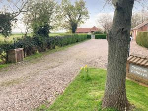 Saltfleetby Saint ClementにあるCloverleafの木の横の砂利道と看板 +5枚の写真