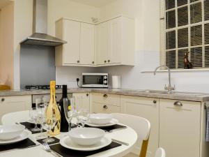 a kitchen with a table with plates and wine glasses at Pear Tree Cottage in Bowness-on-Windermere