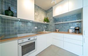 a kitchen with white cabinets and blue tiles at Nice Apartment In Selca With Kitchen in Selca