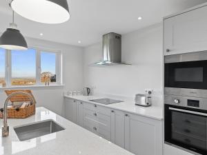 eine weiße Küche mit Spüle und Herd oberen Backofen in der Unterkunft The Keys - Cottage in Sardis + 15 Fotos