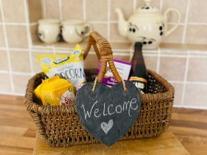 a basket with a welcome sign and a bottle of wine at The Parlour in Earls Croome