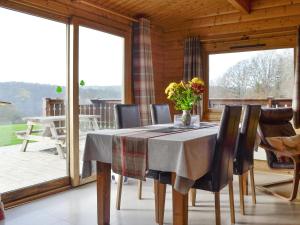 a dining room with a table and chairs and windows at Cider Mill Lodge - Hw7420 in Tintern