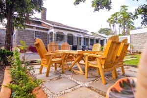 Una mesa de picnic de madera y sillas frente a una casa. en Keyman Address, en Nyeri 18 fotos más