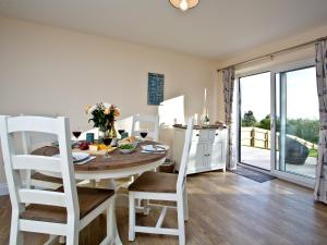 a kitchen and dining room with a table and chairs at Orestone Garden Apartment in Dawlish