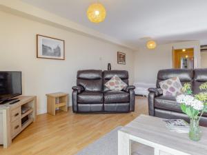 a living room with two leather chairs and a television at 6 Harbour View in Newquay