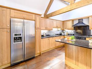 a kitchen with wooden cabinets and a stainless steel refrigerator at Low Barn in Market Bosworth