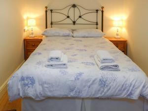 a bedroom with a bed with towels on it at Thwaite Hill Cottage in Braithwaite