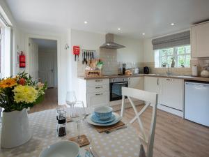 a kitchen with a table with a vase of flowers at The Shambles in Fulletby