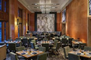 a dining room with tables and chairs and a large screen at The Ritz-Carlton, Bachelor Gulch in Beaver Creek