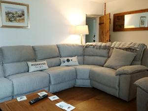 a blue couch in a living room with a table at Eithinog Ganol in Llandwrog +19 photos