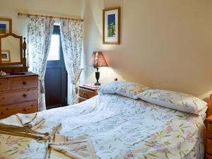 a bedroom with a bed and a dresser and a window at Swallows Nest-18094 in Cloughton +8 photos