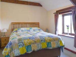 Saint EndellionにあるHaywain - Uk12084のベッドルーム1室(カラフルなキルトのベッド1台付)