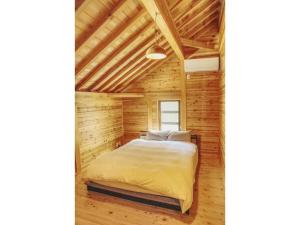 - une chambre dans une cabane en rondins avec un lit dans l'établissement Keiryusou - Vacation STAY 50707v, à Kinokawa