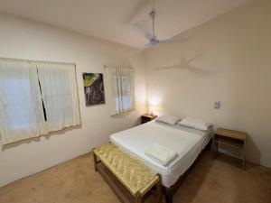 ein Schlafzimmer mit einem weißen Bett und einem Fenster in der Unterkunft la punta surf house 2 in Brisas de Zicatela