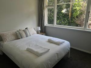 a bedroom with a bed with two towels on it at Darfield Hotel Apartment Home in Darfield