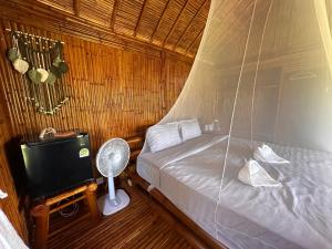 - une chambre avec un lit, un ventilateur et une télévision dans l'établissement Phuree Hut, à Ko Phayam
