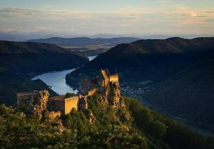 クレムス・アン・デア・ドナウにあるOase Krems - Perle der Wachauの川の横の山頂の城 +2枚の写真