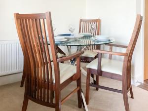 シャンクリンにあるLower Chine Apartmentのダイニングルームテーブル(椅子2脚、ガラステーブル付)