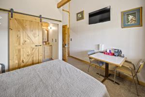 a bedroom with a bed and a table and a tv at Ponderosa Inn in Escalante