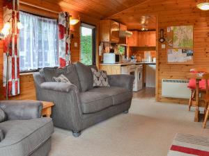 a living room with a couch and a kitchen at Fell View Lodge in Keswick