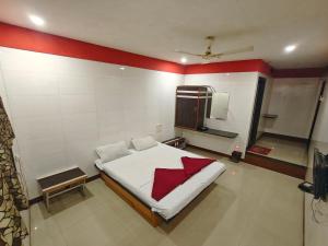 ein Schlafzimmer mit einem Bett und einem Fernseher in der Unterkunft Hotel Vishal in Surat