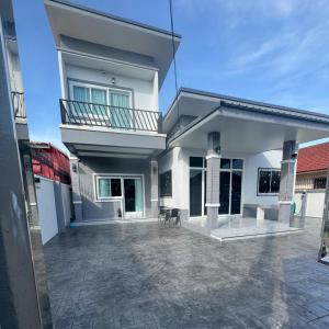 a white house with a balcony and a patio at Together Stay Home in Mae Sai