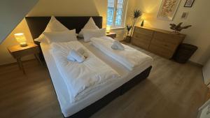 a bedroom with two beds with white sheets and pillows at Wohlfühloase Goslar no 3 in Goslar