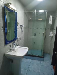 une salle de bain avec un lavabo et une douche en verre dans l'établissement Li Tour International Hotel, à Ikeja