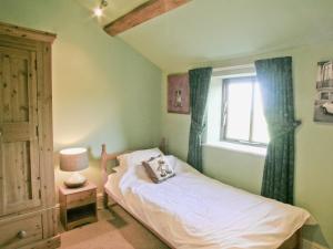 een kleine slaapkamer met een bed en een raam bij The Old Stables in Helsby