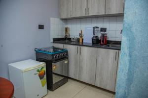 a small kitchen with a stove and a refrigerator at Primera Hotel Kampala in Kampala