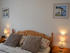 a bedroom with a bed with two lamps on tables at Summer Breeze in St Austell