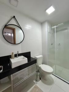 a bathroom with a toilet and a sink and a mirror at Studio Sofisticado 2106 - Próx Aeroporto GRU in Guarulhos