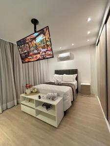 a bedroom with a bed and a tv on the wall at Studio Sofisticado 2106 - Próx Aeroporto GRU in Guarulhos +10 photos