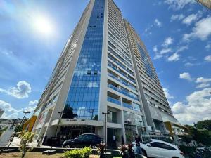 a tall building with cars parked in front of it at Studio Sofisticado 2106 - Próx Aeroporto GRU in Guarulhos