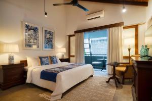 a bedroom with a bed and a desk and a window at Luna Mews - Ward place in Meda-Ela