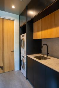 a kitchen with a washing machine and a sink at Base 47 Hakuba by Jade Group in Hakuba