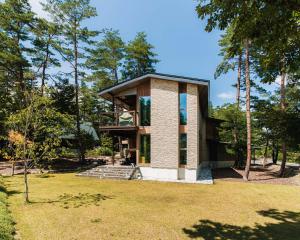a house in the middle of a park with trees at Base 47 Hakuba by Jade Group in Hakuba
