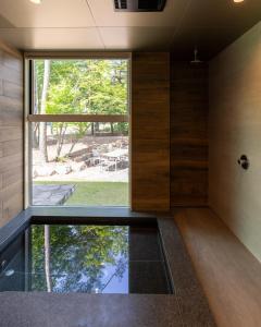a room with a large window and a glass floor at Base 47 Hakuba by Jade Group in Hakuba