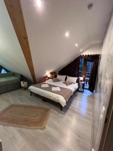 a bedroom with a large bed in a attic at Kalinderu Slope View in Buşteni