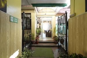 a hallway with wrought iron gates and potted plants at Harmony Sentiments in Jāmb