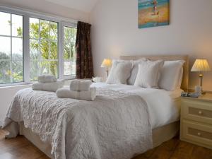a bedroom with a large white bed with windows at The Orangery in Bideford