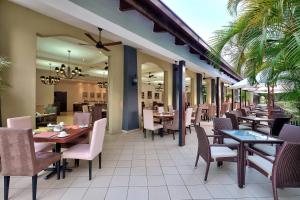 een restaurant met tafels en stoelen op een patio bij Protea Hotel by Marriott Livingstone in Livingstone