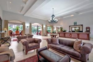 een woonkamer met een bank en stoelen bij Protea Hotel by Marriott Livingstone in Livingstone