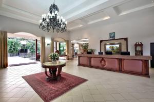 een lobby met een receptie en een tafel met bloemen bij Protea Hotel by Marriott Livingstone in Livingstone +62 foto's