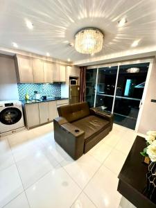 a living room with a couch and a kitchen at Apartment Serenity Wongamat in Pattaya North +47 photos