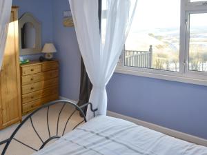 a bedroom with a bed and a window with a view at Rowan Cottage-80119 in Catcleugh +9 photos