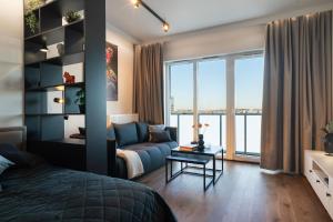 a bedroom with a bed and a living room with a couch at Global Apartments Katowice in Katowice +184 photos